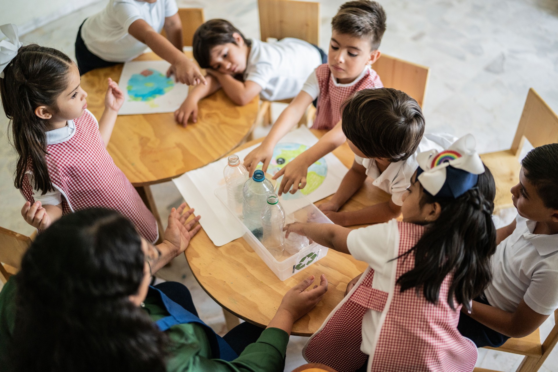 Teacher talking to students about recycling in the classroom at school